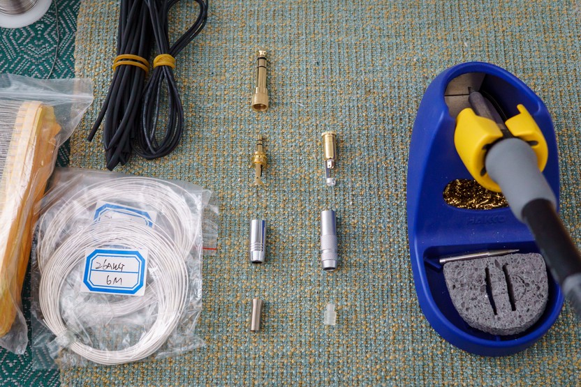 3.5mm plugs, wire, heatshrink, and soldering iron