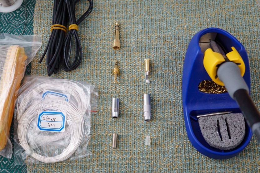 3.5mm plugs, wire, heatshrink, and soldering iron